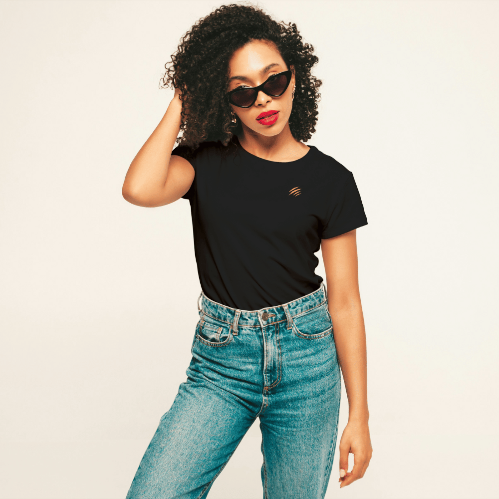 Femme portant un t-shirt noir DAME UN GRRR en coton bio, avec lunettes de soleil et jeans.